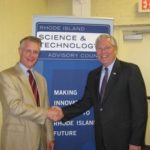 PARTNERING UP: Nicholas Bowen, an IBM vice president, left, said the company has increased its research partnerships in the past 10 years. At right is Gov. Donald L. Carcieri. / 