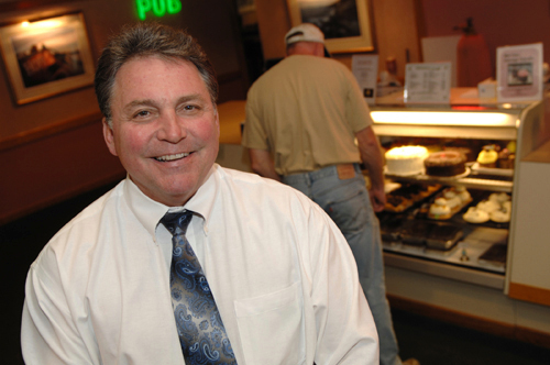 BRINGING HOME THE BACON: Gregg’s Restaurant owner H. Robert Bacon received funding from Washington Trust to buy the chain earlier this year. Behind him, a customer checks out some of the company’s signature desserts. / BRINGING HOME THE BACON: Gregg’s Restaurant owner H. Robert Bacon received funding from Washington Trust to buy the chain earlier this year. Behind him, a customer checks out some of the company’s signature desserts. /