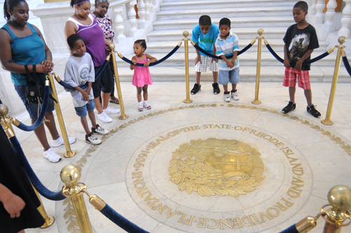 WHAT’S IN A NAME? Visitors to the Rhode Island Statehouse view the state crest – which includes the phrase “Providence Plantations” – in the building’s rotunda. / WHAT’S IN A NAME? Visitors to the Rhode Island Statehouse view the state crest – which includes the phrase “Providence Plantations” – in the building’s rotunda. /