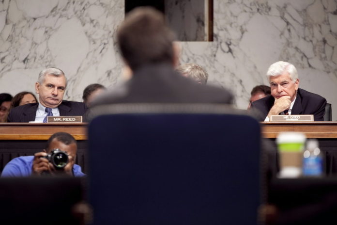 U.S. SEN. JACK REED, left, and Sen. Christopher Dodd, right, listen to Treasury Secretary Timothy Geithner at a Senate Banking Committee hearing in June. / 