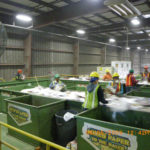 RECYCLED IDEAS: Workers pull contaminants from the paper sorting at R.I. Resource Recovery Corporation’s facility. / 