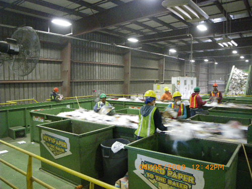 RECYCLED IDEAS: Workers pull contaminants from the paper sorting at R.I. Resource Recovery Corporation’s facility. / RECYCLED IDEAS: Workers pull contaminants from the paper sorting at R.I. Resource Recovery Corporation’s facility. /