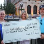 AMICA ESSAY contest winners Alexandra Puleo and John MacLure present a check to Meals on Wheels President Sandi Centazzo (center) during the Aug. 22 WaterFire event in downtown Providence. / 