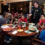 KIDS MEALS: Dana Andrews and his sons, Tyler, 12, Daniel, 18, and Bryan, 10, talk to waiter Scott Myers during their meal at Davenport’s Restaurants in East Providence. /
