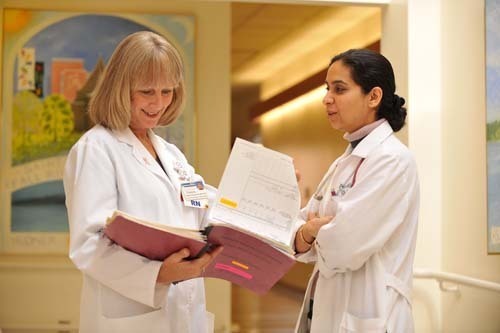 PAULETTE MANSSUER, patient care manager for hematology/medical oncology at Saint Anne’s Hospital, confers with Fareeha Siddiqui, hematologist/medical oncologist, at the hospital’s Hudner Oncology Center. / PAULETTE MANSSUER, patient care manager for hematology/medical oncology at Saint Anne’s Hospital, confers with Fareeha Siddiqui, hematologist/medical oncologist, at the hospital’s Hudner Oncology Center. /