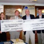 TOURNAMENT CHAIR Andrew Shartenberg, right, and Vice Chairman Cara Conaty, left, present checks to Gary LeFrancois, second from left, vice president of Habitat for Humanity West Bay and Northern Rhode Island and Jay Shartenberg, director of operations at South County Habitat for Humanity. / 