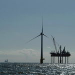 AN INSTALLATION VESSEL erects an offshore wind turbine in waters off the United Kingdom last summer. Deepwater Wind hopes to do the same off Rhode Island. / 