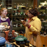 TEA TIME: Erin Mayer, left, manager of Teavana in Providence Place mall, 
speaks with customer Florence Pierre. / 