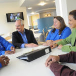 GOOD COVERAGE: Blue Cross & Blue Shield of Rhode Island CEO James E. Purcell, second from left, speaks with staff at the company’s new downtown Providence headquarters, opened this year. / 