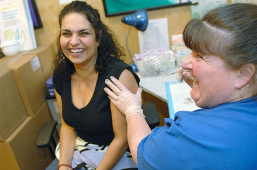 TAKING A SHOT: Aelene Asprinio receives a flu shot from Lori Larocque at the Wellness Center in Providence last week. / TAKING A SHOT: Aelene Asprinio receives a flu shot from Lori Larocque at the Wellness Center in Providence last week. /