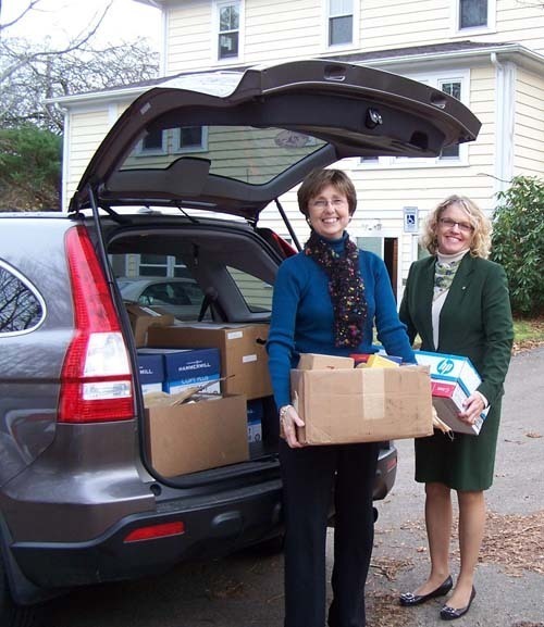LESLIE NELSON, DVRCSC volunteer coordinator, left and Elizabeth Eckel, senior vice president of marketing, The Washington Trust Co., unload boxes of cell phones that bank customers donated during October, Domestic Violence Awareness Month. / LESLIE NELSON, DVRCSC volunteer coordinator, left and Elizabeth Eckel, senior vice president of marketing, The Washington Trust Co., unload boxes of cell phones that bank customers donated during October, Domestic Violence Awareness Month. /