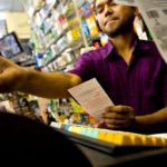 A CONVENIENCE STORE EMPLOYEE sells Mega Millions tickets in New York last year. The game will start in Rhode Island on Sunday. / 