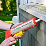 USING A CAULKING GUN, which can seal against air and water, is one way to weatherize a home. / 