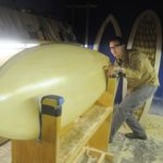 LOAN WOLF: Kevin Cunningham checks the line detail on a custom surfboard built at his Providence company, Spirare Surfboards. The startup was a recent recipient of an EDC micro-loan. / 