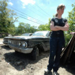 WASHED OUT: Wendy Field, co-owner of SD Concept Engineering, stands near cars that were slated to be customized and made into performance cars. March flooding essentially totaled the cars. / 