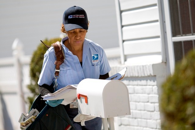 A POSTAL WORKER delivers mail on Long Island in New York last year. The elimination of Saturday delivery would save the Postal Service $3 billion a year. / A POSTAL WORKER delivers mail on Long Island in New York last year. The elimination of Saturday delivery would save the Postal Service $3 billion a year. /