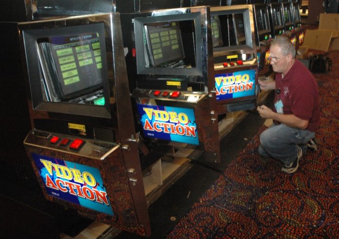 A TECHNICIAN FINISHES installing new video lottery terminals at Newport Grand in 2008. The Newport City Council opposes turning the venue into a casino. / 