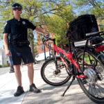 Rhode Island School of Design Public Safety Officer Tony LeDoux, above, shows off an electric bicycle RISD recently purchased for patrols. A lithium-ion battery positioned above the rear wheel powers a small electric engine that propels the bike up to 15 mph without pedaling. Charged via a standard electrical outlet, the bike holds enough energy to last an entire eight-hour shift and releases no emissions. / 