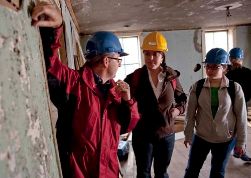 PRESERVE AND PROTECT: Arnold Robinson, a RWU historic-preservation instructor, in the Waterman Tavern with students Kasey Beckwith, left, and Sydney School. / PRESERVE AND PROTECT: Arnold Robinson, a RWU historic-preservation instructor, in the Waterman Tavern with students Kasey Beckwith, left, and Sydney School. /