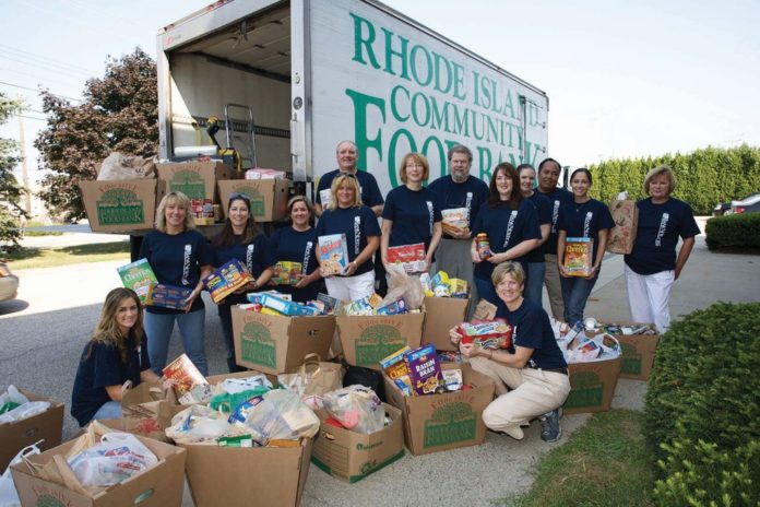 THOMAS W. KELLY, back row center, BankNewport president and CEO, and Sandra J. Pattie, center, executive vice president and chief operating officer, join bank employees in loading the more than three-quarters of a ton of food collected during BankNewport&rsquo;s summer food drive to benefit the Rhode Island Community Food Bank. / 
