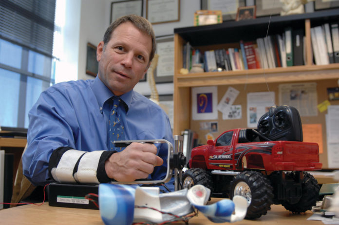 UNDER CONTROL: Joseph “Trey” Crisco is a Lifespan employee who is developing physical therapy devices that re-engineer toys’ controls to help children practice therapeutic motions. / UNDER CONTROL: Joseph “Trey” Crisco is a Lifespan employee who is developing physical therapy devices that re-engineer toys’ controls to help children practice therapeutic motions. /