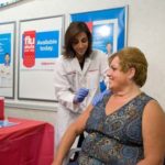 SHOT IN THE ARM: CVS pharmacist Papatya Tankut, left, administers the flu vaccine. CVS offers flu shots at its pharmacies. / 