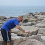 Businesses dive into beach cleanup DOING THEIR PART: Chris Cullion, an employee with DiSanto Priest & Co., picks up a piece of trash during a Save The Bay cleanup last year. The company encourages its employees to help with beach cleanups. /