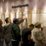 PEOPLE check the jobs board at a Denver Workforce Center, part of the Denver Office of Economic Development, in Denver, Colo.  / 