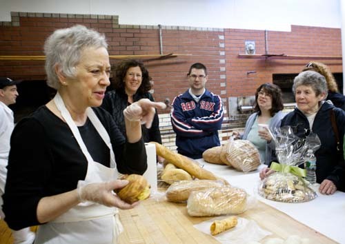 TOUR DE COURSE: Carol Scialo Gaeta, above wearing an apron, co-owner of Scialo Brothers Bakery on Atwells Avenue, discusses the bakery’s history with a tour group. / TOUR DE COURSE: Carol Scialo Gaeta, above wearing an apron, co-owner of Scialo Brothers Bakery on Atwells Avenue, discusses the bakery’s history with a tour group. /