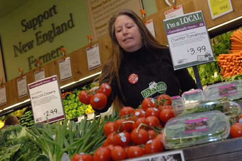 WHOLE PICTURE: Holly Dion, Whole Foods Rhode Island forager, with a display of tomatoes grown at Maine’s Backyard Farms. / WHOLE PICTURE: Holly Dion, Whole Foods Rhode Island forager, with a display of tomatoes grown at Maine’s Backyard Farms. /