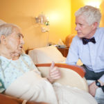 CARE-GIVING: Dr. Edward W. Martin, right, chief medical officer at Home & Hospice Care of Rhode Island, speaks with patient John Paliotta. The organization has a waiting list for its 24-bed facility. / 