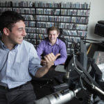 RIDING THE WAVES: Bryant students Rick McLaughlin, WJMF general manager, right, and Tyler Pepe, program director, at work in the station's studio. / 