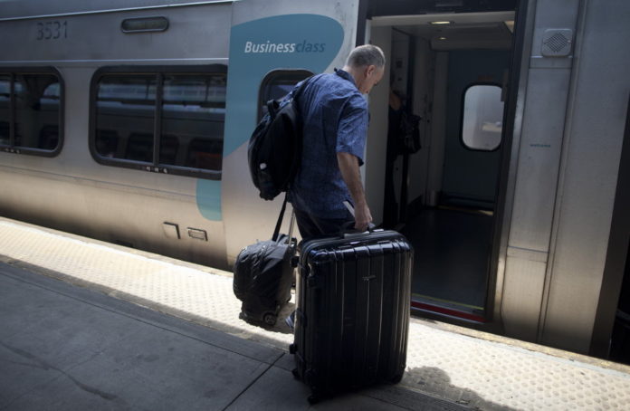 A PASSENGER boards an Amtrak Acela passenger train at Union Station in Washington D.C. / 