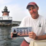LIGHTING THE WAY: David Zapatka, president of the Friends of the Plum Beach Lighthouse, with a specialty plate that has helped raise nearly $90,000 for the group since January 2010. / 