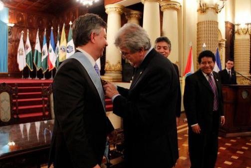 RAFAEL Espada, vice president of Guatemala, places the Order of the Quetzal sash on the shoulders of Stephen Houston. / RAFAEL Espada, vice president of Guatemala, places the Order of the Quetzal sash on the shoulders of Stephen Houston. /