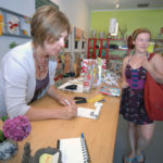 CREATING SUCCESS: Line Daems, left, rings up customer Tabitha Genetry at Kreatelier Creations. Daems took CWE's Power Up! class four years ago. / PBN PHOTO/BRIAN MCDONALD