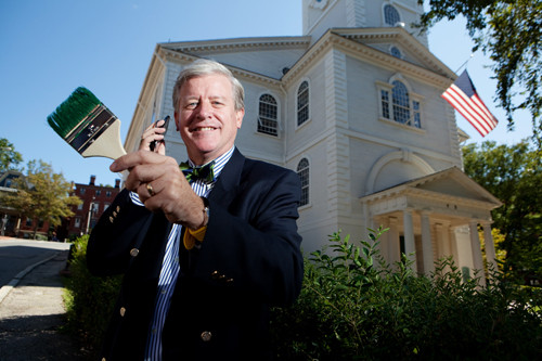 LOUD AND CLEAR: Bob Burke, in front of Providence’s historic First Baptist Church, a stop along the Independence Trail he created. The trail is marked by a painted, green line along the sidewalk that visitors can follow, using cellphones to access information on each stop. / PBN PHOTO/RUPERT WHITELEY LOUD AND CLEAR: Bob Burke, in front of Providence’s historic First Baptist Church, a stop along the Independence Trail he created. The trail is marked by a painted, green line along the sidewalk that visitors can follow, using cellphones to access information on each stop. / PBN PHOTO/RUPERT WHITELEY