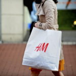 A PEDESTRIAN carries an H&M-branded shopping bag from a Hennes & Mauritz AB store. / BLOOMBERG NEWS FILE PHOTO AIDAN CRAWLEY