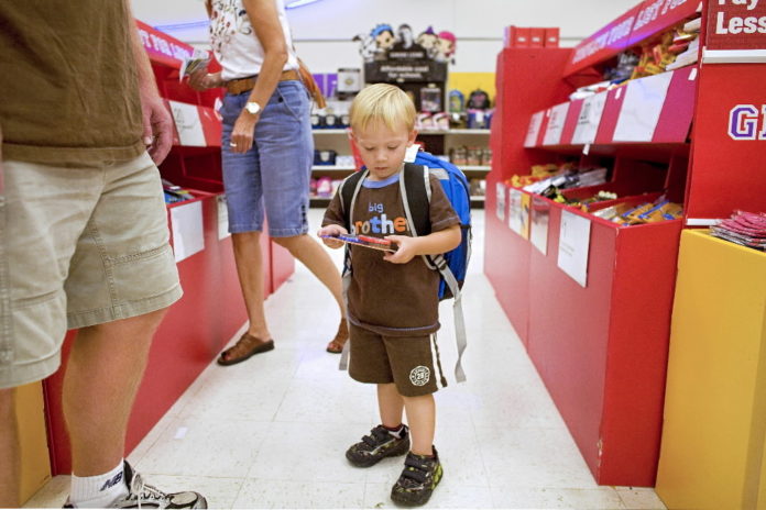 EVAN OLDS, 3, who is about to start preschool, wears a new backpack and looks at other school supplies while shopping with his father Rich at a Super Target store in Littleton, Colo. / BLOOMBERG NEWS FILE PHOTO/MATTHEW STAVER