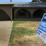 AN Auction.com foreclosure sign is displayed outside of a house for sale in Phoenix, Ariz. / BLOOMBERG NEWS FILE PHOTO JOSHUA LOTT