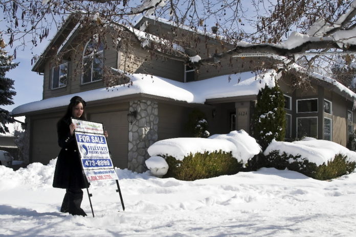 SINGLE-family home sales in the Ocean State rose 19 percent in December compared with the same month a year earlier, but the steady flow of deals for distressed properties helped drive the median sales price down 14 percent, the Rhode Island Association of Realtors said Thursday. / BLOOMBERG NEWS FILE PHOTO DAVID CALVER
