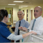 Firm a player in trade-show game WHERE THERE'S A WILL ... : Willwork Exhibit & Event Services President William F. Nixon Sr., center, and General Manager David King speak with administrative assistant Karen Brousseau. The company survived a devastating fire in 2008, coming back stronger. / PBN PHOTO/BRIAN MCDONALD