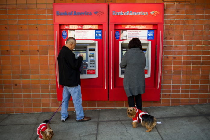 PEDESTRIANS use Bank of America Corp. automated teller machines in San Francisco, Calif. Bank of America Corp., the second-largest U.S. lender, swung to a fourth-quarter profit as the company sold assets and built capital faster than expected. / BLOOMBERG NEWS FILE PHOTO DAVID PAUL MORRIS