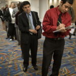 JOB seeker David Caballero, 23, right, fills out a form before entering a National Career Fairs job fair in San Diego, Calif. The jobless rate in Rhode Island increased to 10.8 percent in December. / BLOOMBERG NEW FILE PHOTO DAVID MAUNG