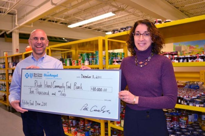 RHODE ISLAND COMMUNITY FOOD BANK recently received a $10,000 donation from Blue Cross & Blue Shield of Rhode Island to support the nonprofit’s Holiday Meal Drive. Pictured from left: Rhode Island Community Food Bank CEO Andrew Schiff accepts a symbolic check from Michele Lederberg, chief administration officer at BCBSRI.