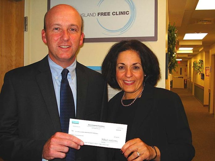 BILL FITZGERALD, senior vice president at Amica Mutual Insurance Co. and secretary of the Rhode Island Free Clinic board of directors, presents the first payment of the three-year, $22,500 grant to Marie Ghazal, CEO of the Rhode Island Free Clinic.
