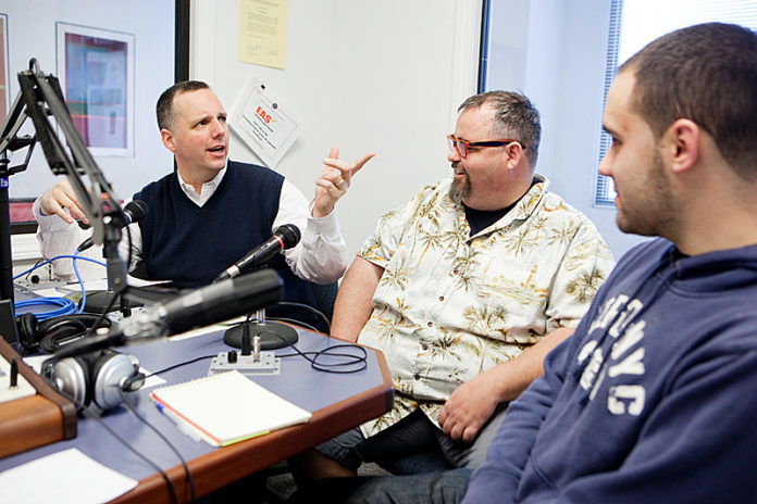 BEHIND THE MIC: Pawtucket Mayor Donald R. Grebien, left, interviews city restaurateurs Jack Doherty and Brandon Harnois, right, for his weekly radio show, “The Mayor’s Corner.” / PBN PHOTO/RUPERT WHITELEY