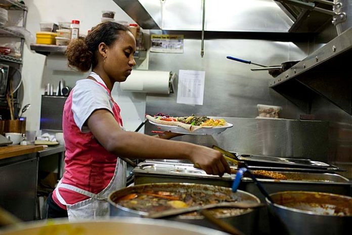 BACK TO ITS ROOTS: Abyssinia employee Yirgalem Weldemichael in the restaurant's kitchen. The Ethiopian eatery is forming a partnership with the Providence Granola Project. / PBN PHOTO/DAVID LEVESQUE
