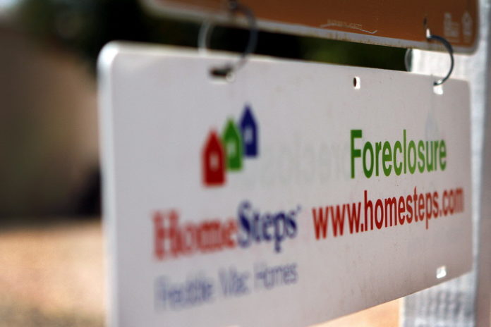 A foreclosure signs hangs outside of a home in Phoenix, Ariz. / BLOOMBERG NEWS FILE PHOTO JOSHUA LOTT