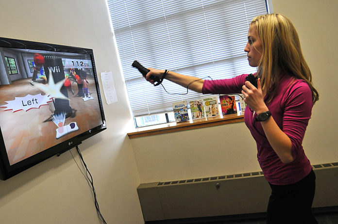 MORE THAN A GAME: Kathy Palmer, a senior research assistant at Lifespan, demonstrates how Wii video games attempt to improve health. / PBN PHOTO/FRANK MULLIN